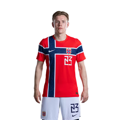 Norges fotballag 2026 VM-drakt (spillerversjon/kampversjon) — Midtbanespillere: nr.19 Thelo AASGAARD, nr.21 Andreas SCHJELDERUP, nr.22 Oscar BOBB, nr.23 Jens Petter HAUGE